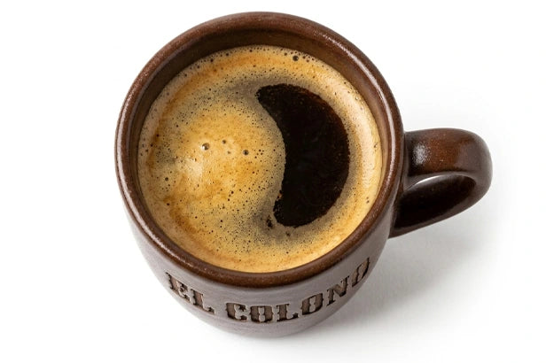 Taza de café negro recién preparado con el logotipo de El Colono
